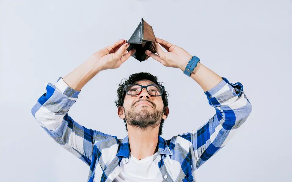 man holding empty wallet over his head